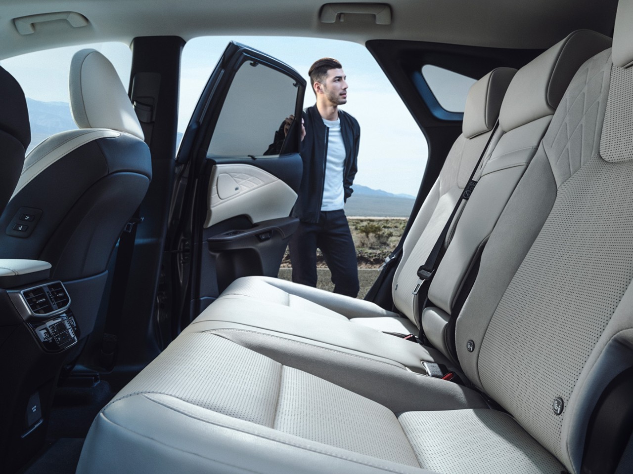 A man holding open a rear passenger door of the Lexus RX