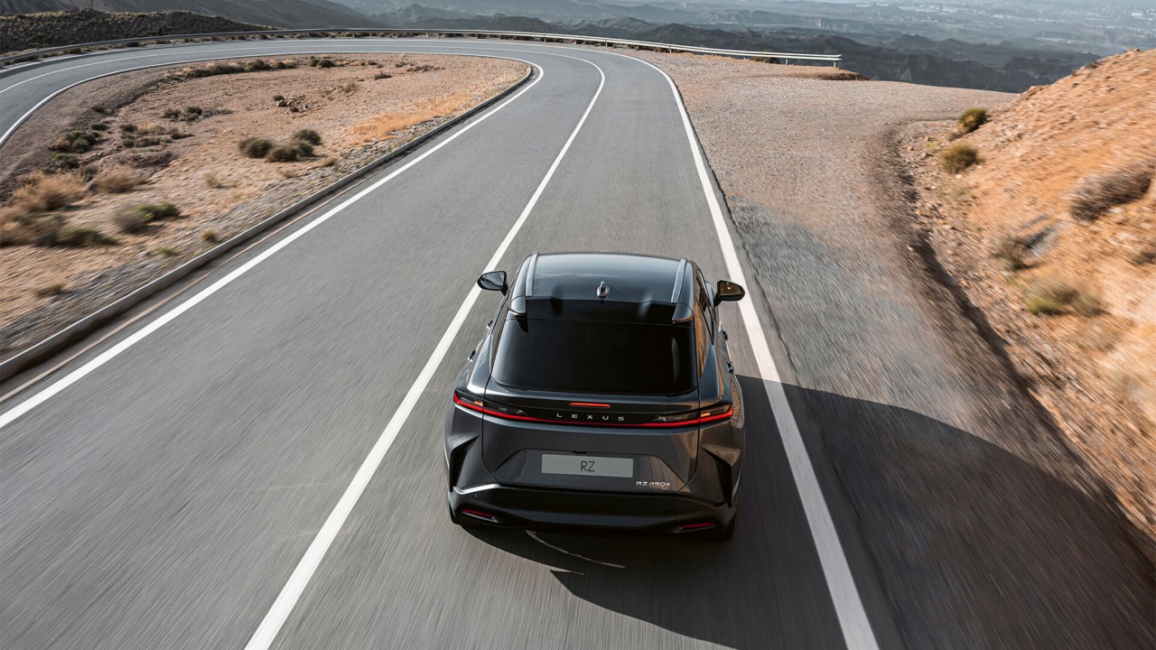 Rear view of the Lexus RZ approaching a corner 