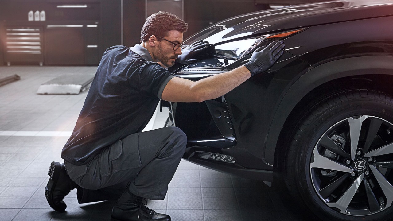 A mechanic next to a Lexus