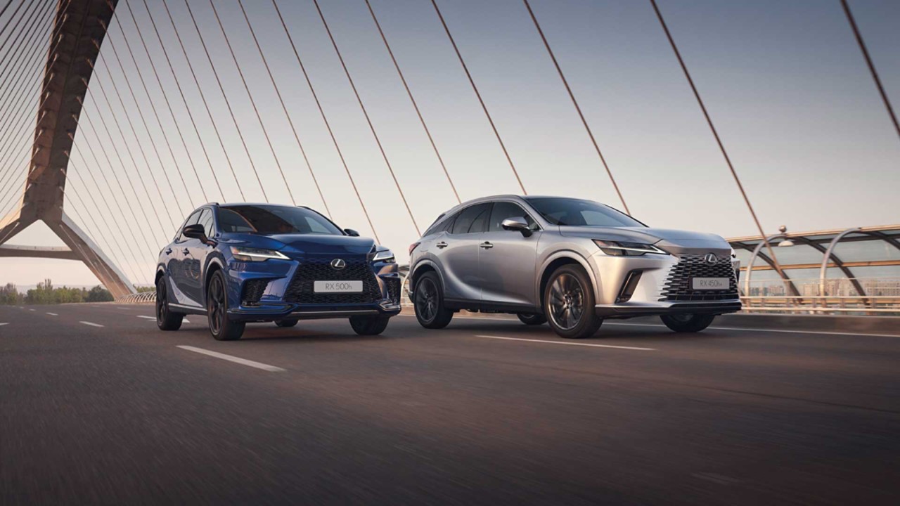 Lexus RX 500h and RX 450h+ driving across a bridge