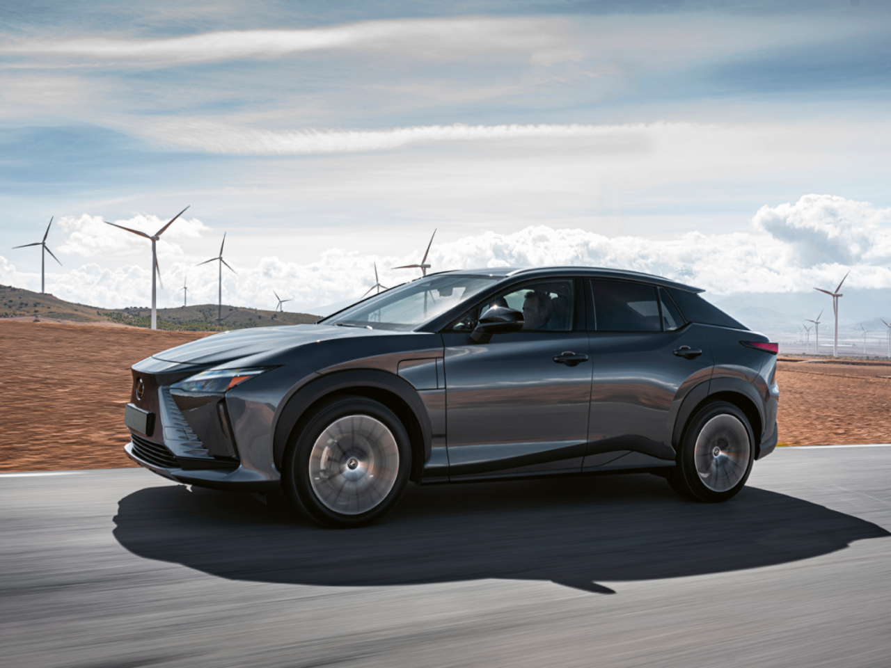 Lexus RZ driving through a wind farm